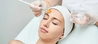 Woman receiving facial treatment with brush